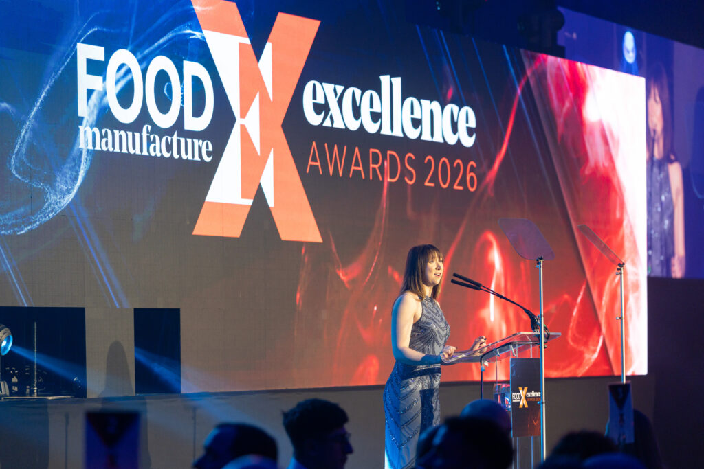 Woman speaking at a lectern with Food Manufacture Excellence Awards 2026 backdrop