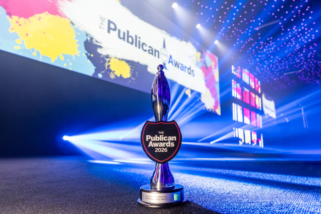 The Publican Awards 2026 trophy on carpet with illuminated event stage and colourful screen backdrop