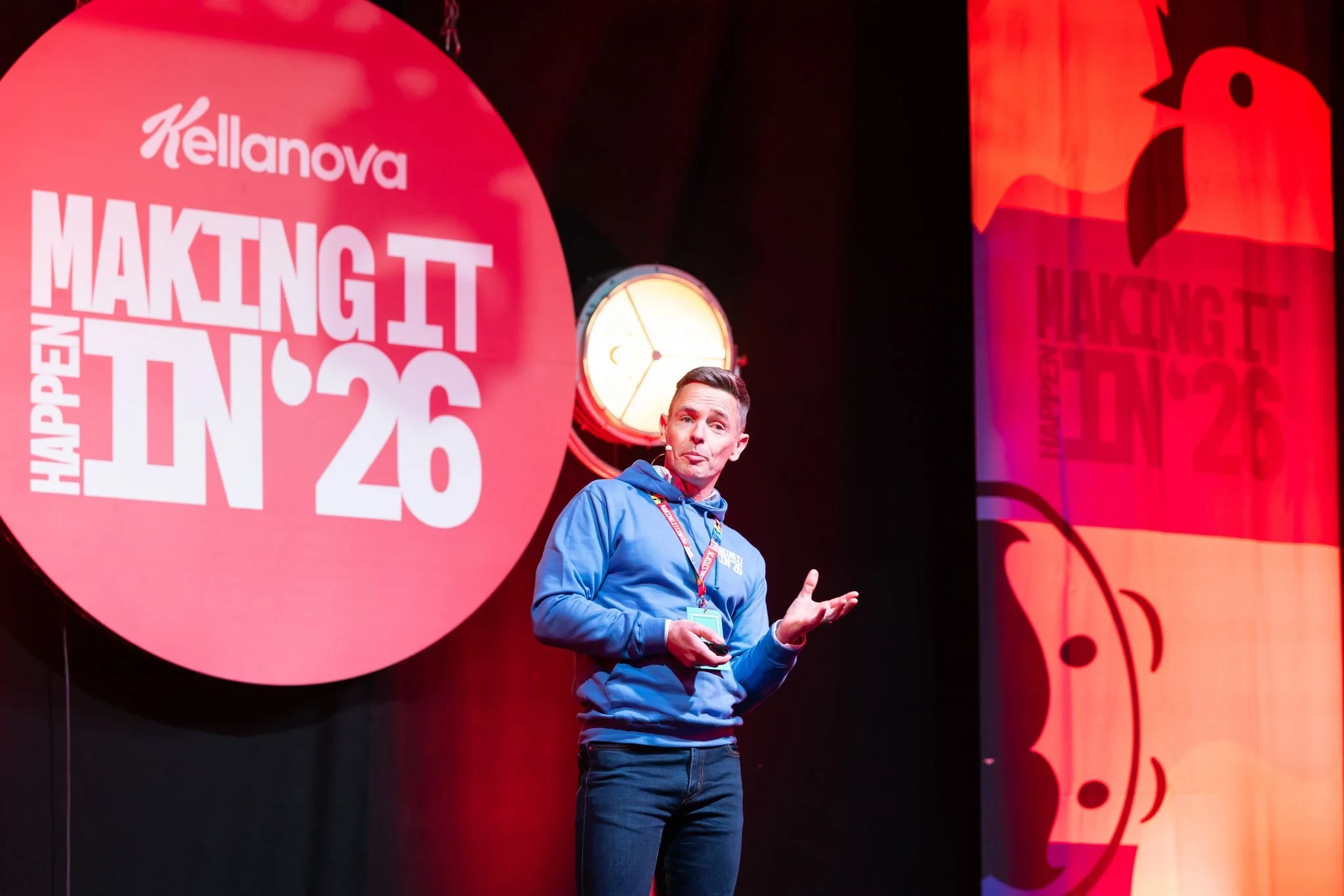 A presenter in a blue hoodie speaks on stage at the Kellanova Conference 2026 in Manchester.