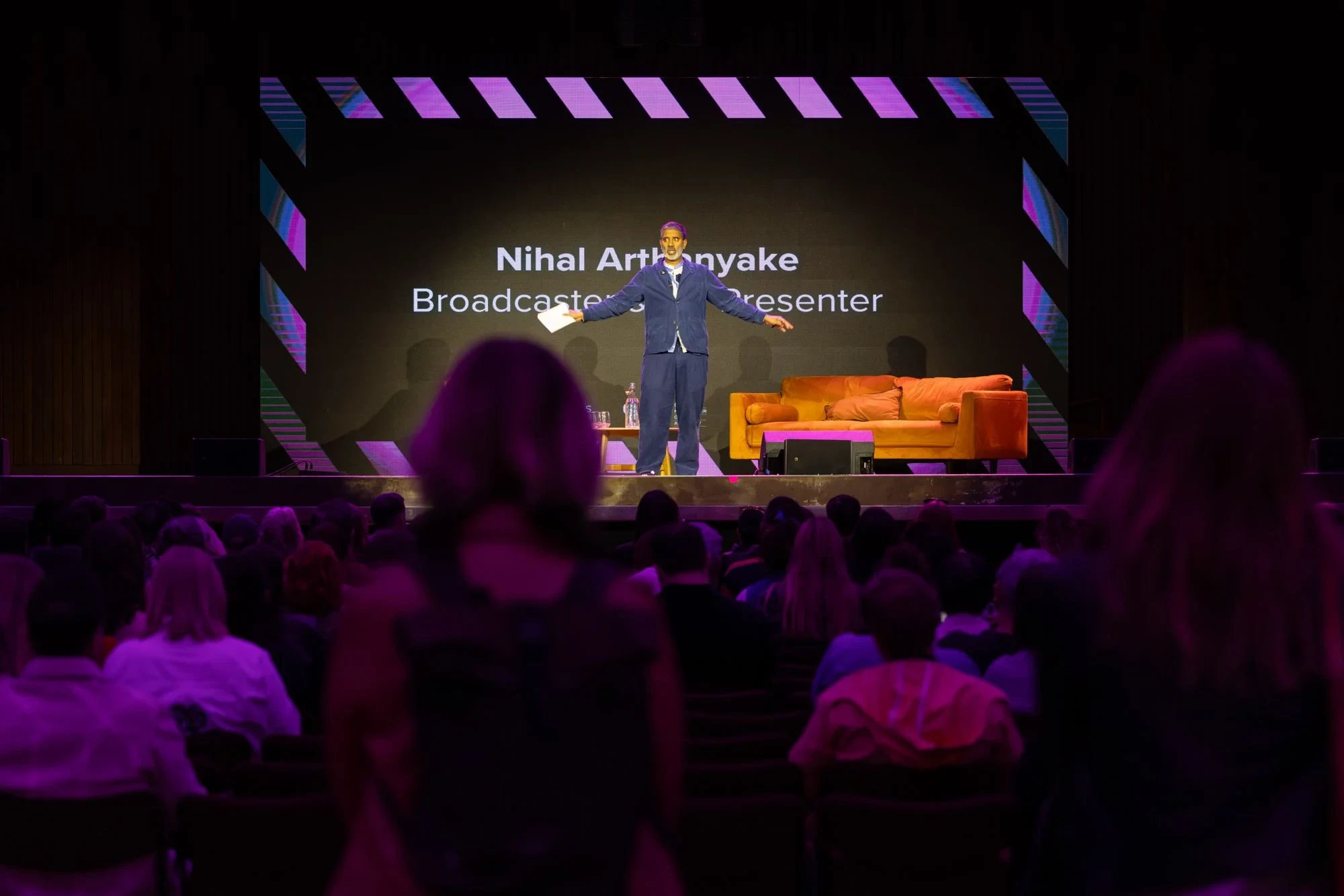Broadcaster Nihal Arthanayake presenting on stage at the GM Creative Industries Exchange in New Century Hall, Manchester.
